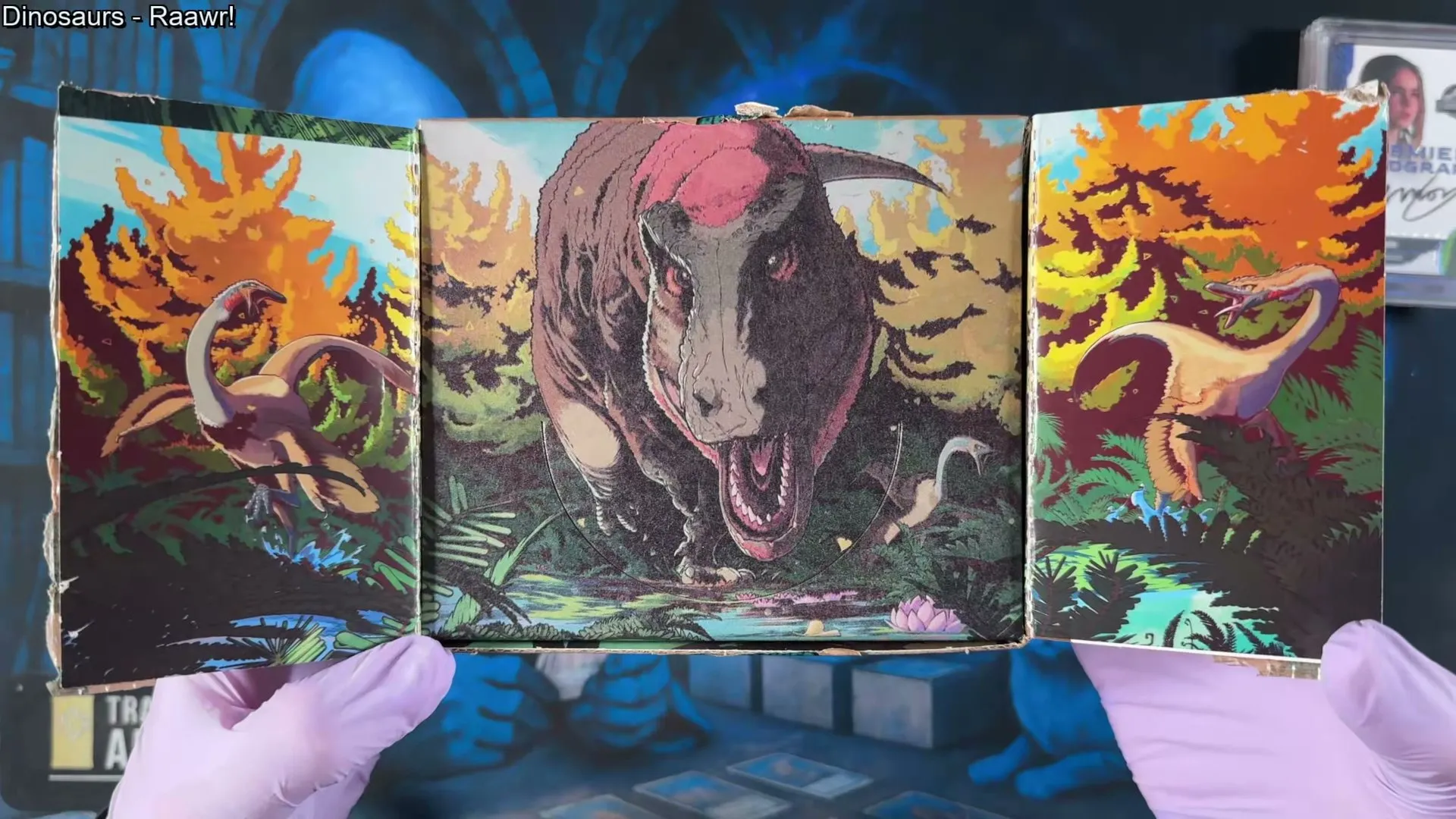 The box laid flat showing the painted Tyrannosaurus panorama across the interior panels