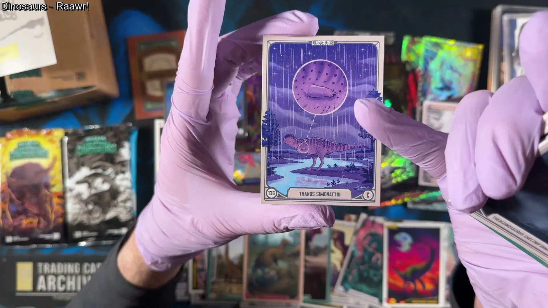 The Thanos simonattoi card - a small short-armed dinosaur with rosy cheeks standing under a purple moon