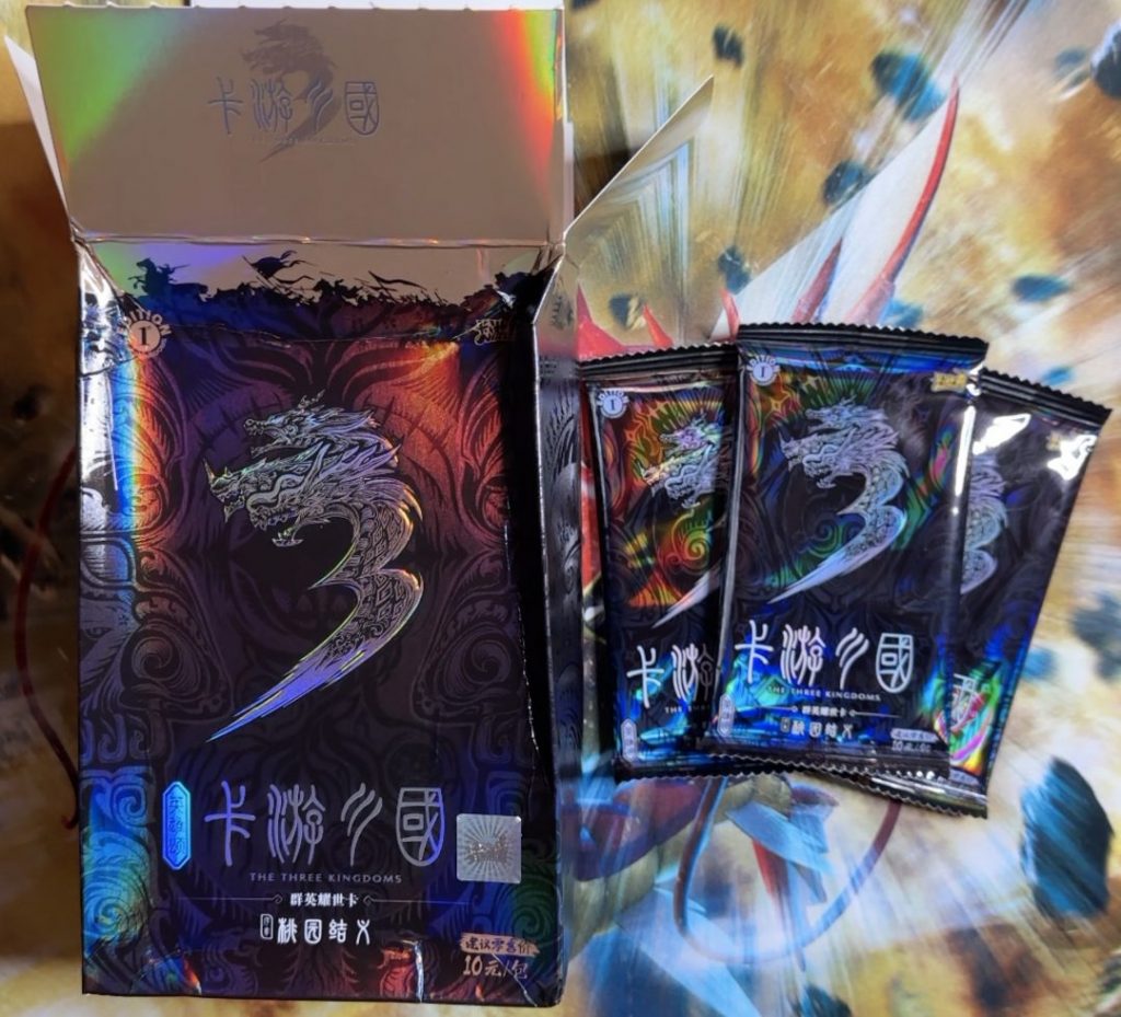 The Kayou Three Kingdoms box opened with some packs on display next to it.