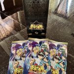 Kayou's Saint Seiya trading cards open with 3 packs on display